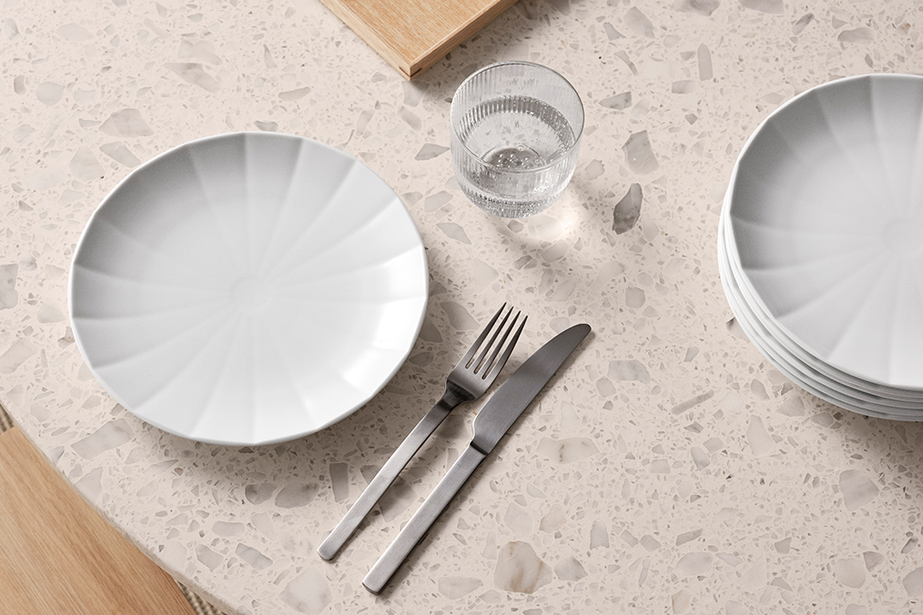 Et smukt marmorbord danner baggrund for den fine Hvide Facet Middagstallerken